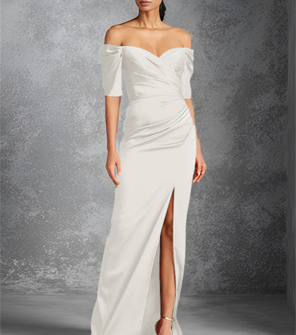Vestido de novia de corte recto/columna, con hombros descubiertos, manga corta y largo hasta el suelo, con abertura frontal. 