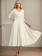 Vestido de corte A, escote en V, largo hasta la rodilla, de gasa, encaje, con lentejuelas y pedrería para la madre de la novia. 
