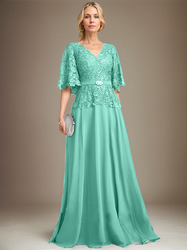 Vestido de novia de corte A, escote en V, largo hasta el suelo, de gasa y encaje, con broche de cristal y pedrería. 