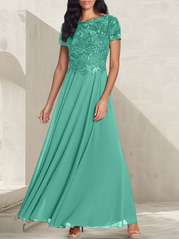 Vestido largo de corte A, color gris carbón, con escote redondo y detalles de pedrería, ideal para la madre de la novia.