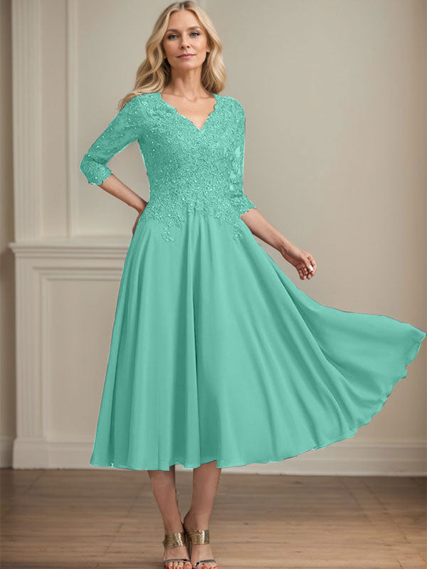 Vestido de corte A, escote en V, largo hasta la rodilla, de gasa, encaje, con lentejuelas y pedrería para la madre de la novia. 