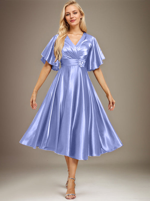 Vestido de novia de satén elástico, corte en A, escote en V, largo hasta la rodilla, con cuentas y pliegues. 