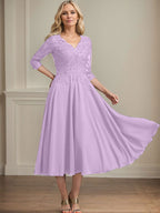 Vestido de corte A, escote en V, largo hasta la rodilla, de gasa, encaje, con lentejuelas y pedrería para la madre de la novia. 