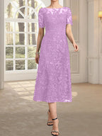 Vestido de novia de encaje con lentejuelas, corte en A, escote redondo ilusión y largo hasta la rodilla.