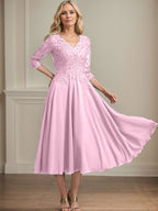 Vestido de corte A, escote en V, largo hasta la rodilla, de gasa, encaje, con lentejuelas y pedrería para la madre de la novia. 