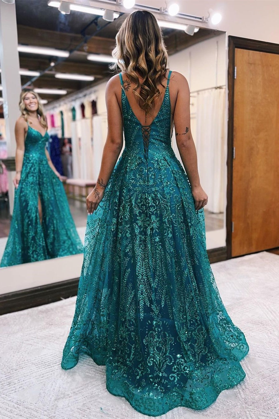 Robe de bal longue trapèze à fines bretelles en tulle et dentelle, sans manches et fendue.