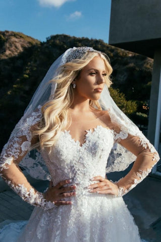 Vestido de novia princesa de corte princesa, escote corazón, manga larga y encaje.