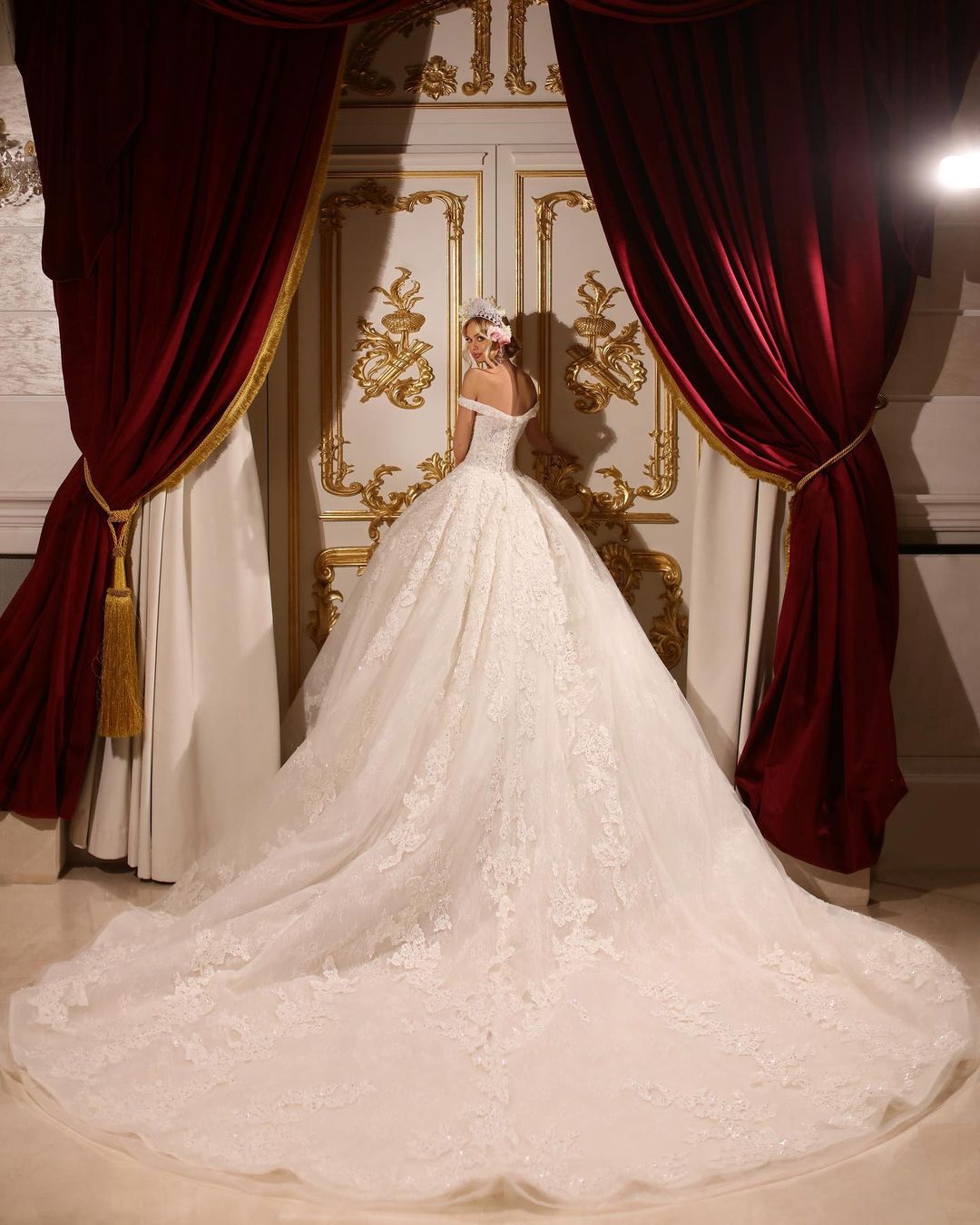 Vestido de novia largo de corte A, con hombros descubiertos, apliques, pedrería y cola.
