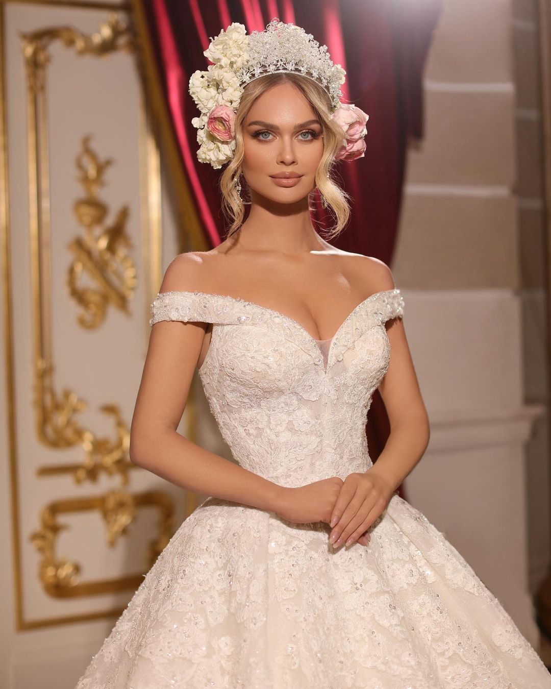 Vestido de novia largo de corte A, con hombros descubiertos, apliques, pedrería y cola.
