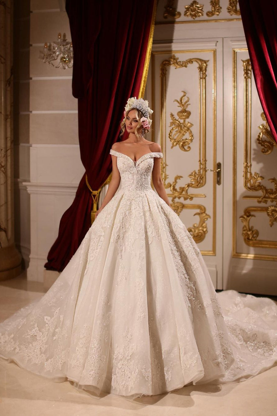 Vestido de novia largo de corte A, con hombros descubiertos, apliques, pedrería y cola.