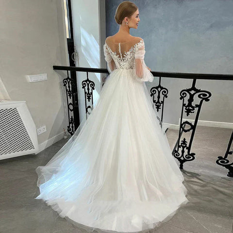Vestido de novia blanco de lujo, de tul con apliques de encaje, escote redondo, corte en A y largo hasta el suelo. 