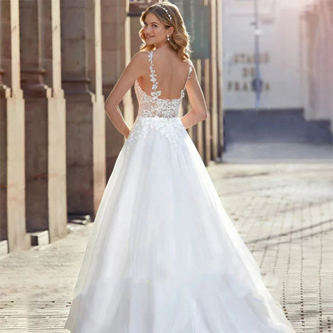 Robe de mariée sirène dos nu en dentelle luxueuse, épaules dénudées, sans manches, ornée d'appliqués et de fines bretelles, collection 2025. Sexy.