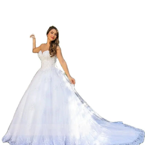 Robe de mariée blanche de luxe, dos nu, décolleté en cœur, ornée d'appliqués, en tulle de perles et de cristaux, style saoudien. 