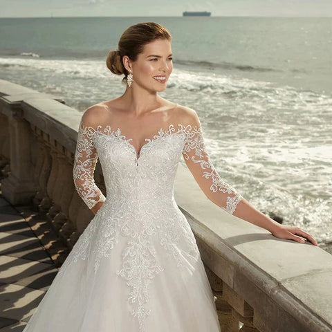 Vestido de novia MACDUGAL exquisito con mangas tres cuartos, escote redondo, encaje, encantador aplique en la espalda y doble botón. 