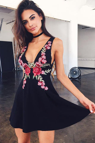 Robe courte noire simple, trapèze, col V et dos nu, idéale pour les fêtes de fin d'année.