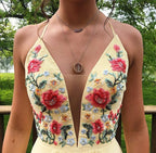 Robe de bal simple en mousseline de soie, coupe trapèze, col en V, dos croisé et broderies.