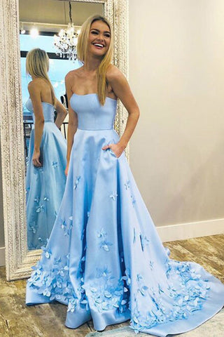 Robe de bal longue bleu ciel en satin, décolleté cœur, coupe trapèze, ornée d'appliqués floraux 3D.