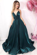 Vestido de fiesta brillante, corte en A, escote en V, tirantes finos, espalda descubierta, color verde oscuro con bolsillos.