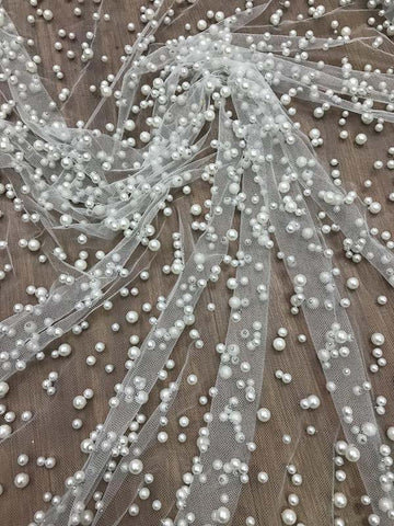 Robe de bal longue en tulle lavande, ornée de perles, à fines bretelles et fente.