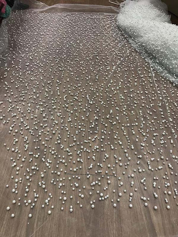 Robe de bal longue en tulle lavande, ornée de perles, à fines bretelles et fente.