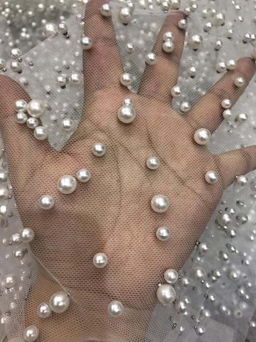 Robe de bal longue en tulle lavande, ornée de perles, à fines bretelles et fente.