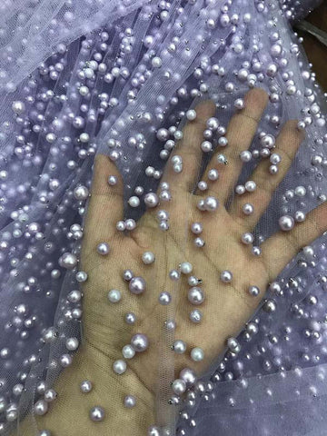 Robe de bal longue en tulle lavande, ornée de perles, à fines bretelles et fente.