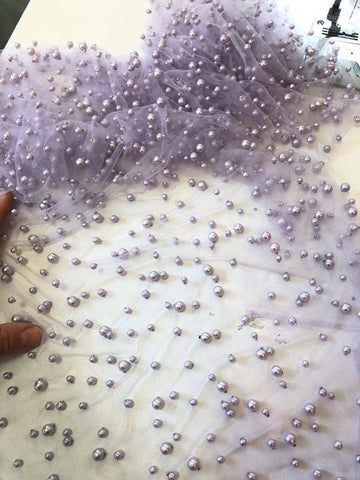 Robe de bal longue en tulle lavande, ornée de perles, à fines bretelles et fente.