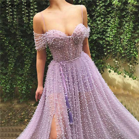 Robe de bal longue en tulle lavande, ornée de perles, à fines bretelles et fente.