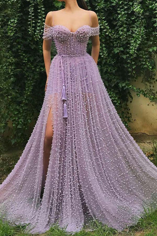 Robe de bal longue en tulle lavande, ornée de perles, à fines bretelles et fente.