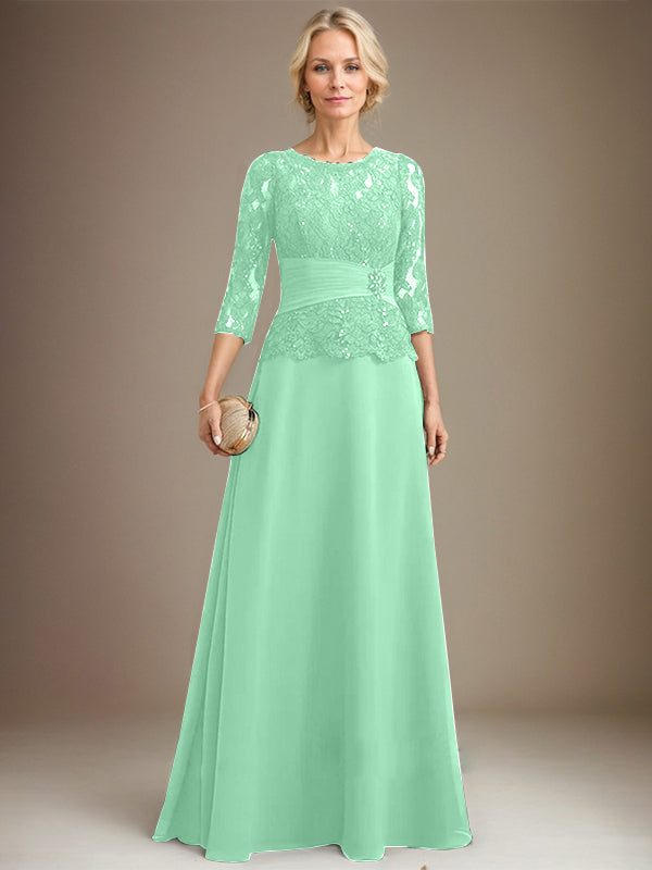 Robe de mariée longue en mousseline de soie et dentelle, coupe trapèze, décolleté illusion, ornée de sequins plissés et de perles. 