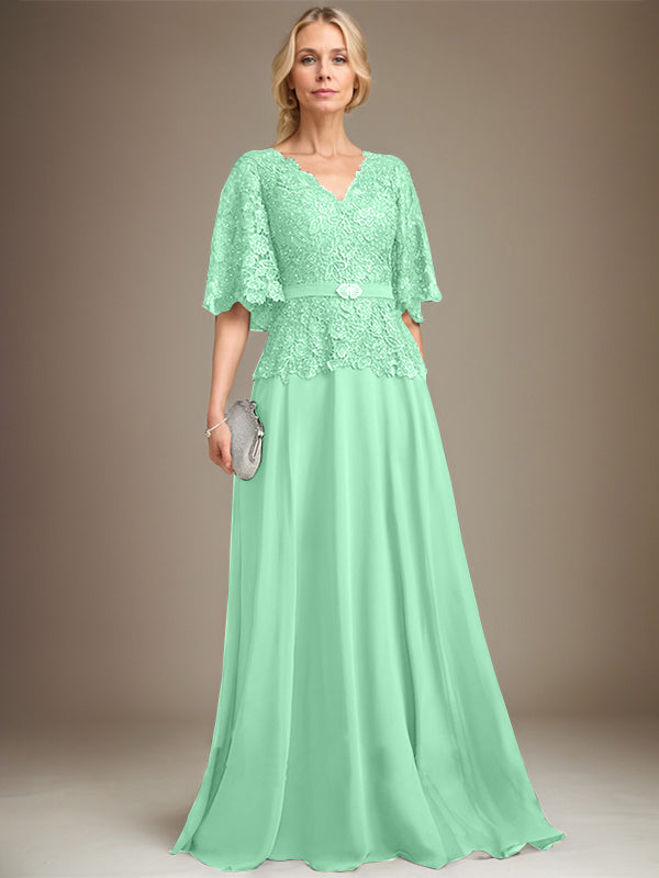 Vestido de novia de corte A, escote en V, largo hasta el suelo, de gasa y encaje, con broche de cristal y pedrería. 