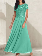 Vestido largo de corte A, color gris carbón, con escote redondo y detalles de pedrería, ideal para la madre de la novia.