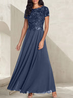 Vestido largo de corte A, color gris carbón, con escote redondo y detalles de pedrería, ideal para la madre de la novia.
