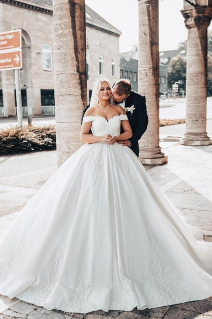 Vestido de novia de corte princesa con escote corazón y hombros descubiertos, con apliques.