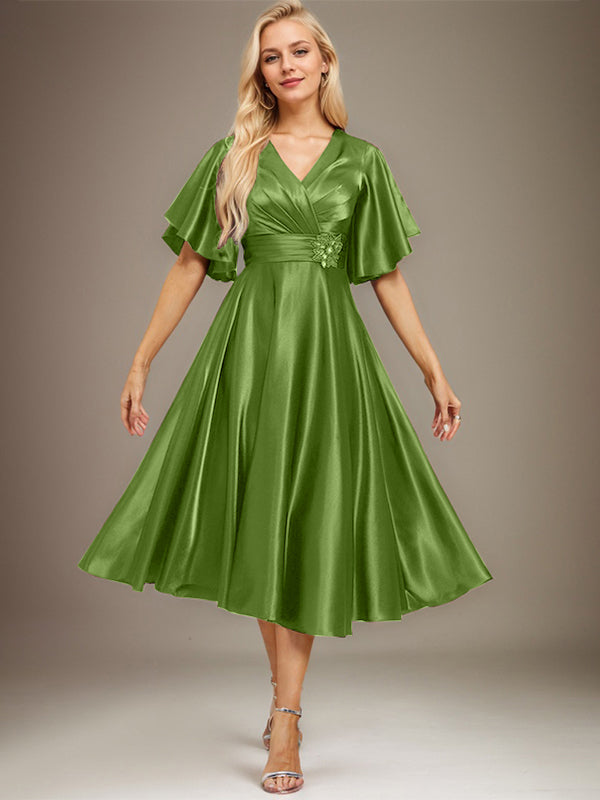 Vestido de novia de satén elástico, corte en A, escote en V, largo hasta la rodilla, con cuentas y pliegues. 