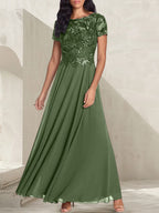 Vestido largo de corte A, color gris carbón, con escote redondo y detalles de pedrería, ideal para la madre de la novia.