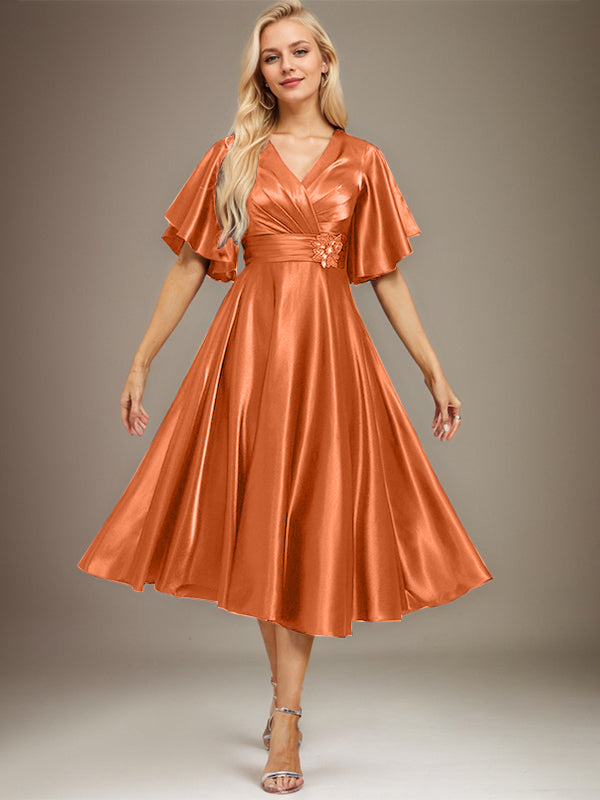 Vestido de novia de satén elástico, corte en A, escote en V, largo hasta la rodilla, con cuentas y pliegues. 