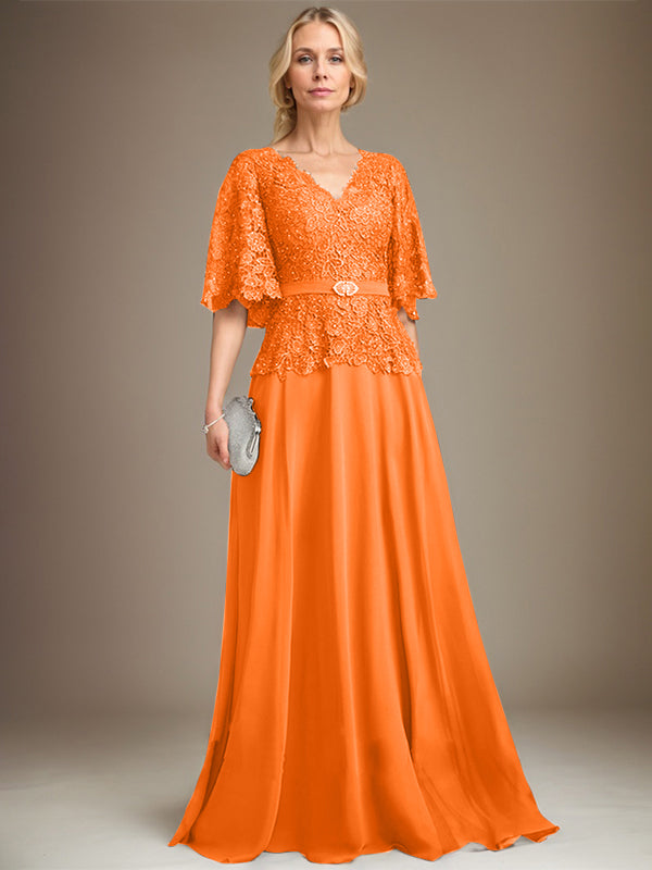 Vestido de novia de corte A, escote en V, largo hasta el suelo, de gasa y encaje, con broche de cristal y pedrería. 