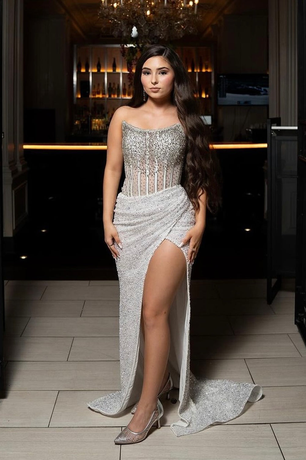 Robe de bal longue moulante à sequins sans bretelles et fente, ornée d'un corset et de paillettes.