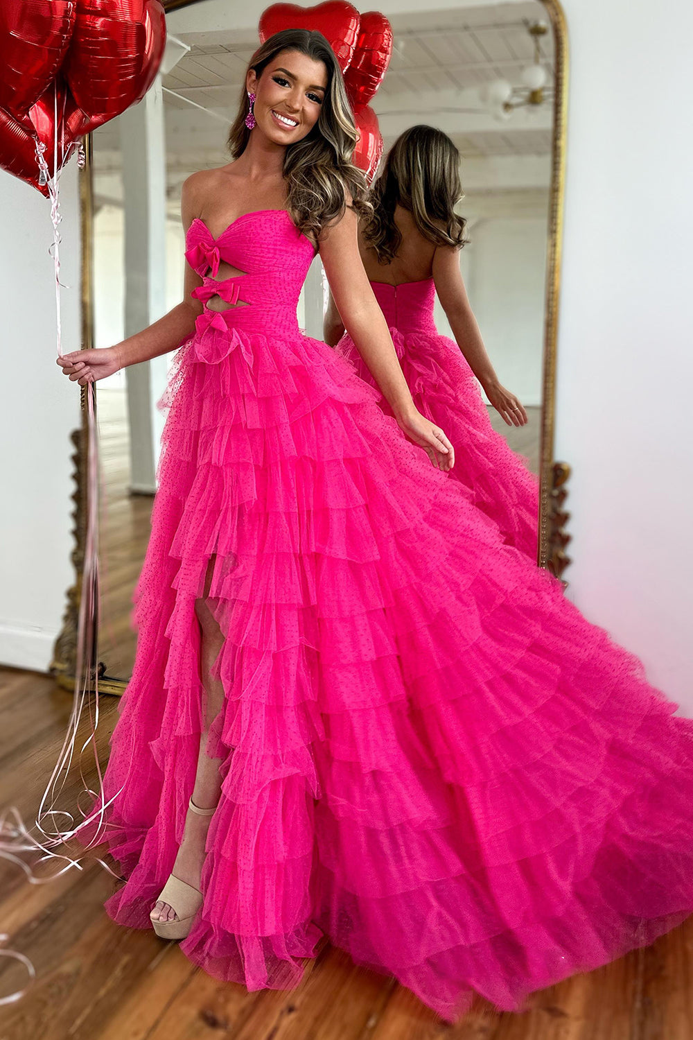 Robe de bal longue fuchsia à décolleté cœur, coupe trapèze, en tulle à volants et fente