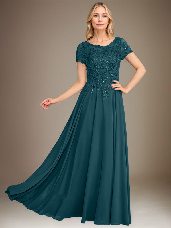 Robe de mariée longue en mousseline de soie, coupe trapèze, décolleté rond, ornée d'appliqués et de sequins, idéale pour la mère de la mariée. 