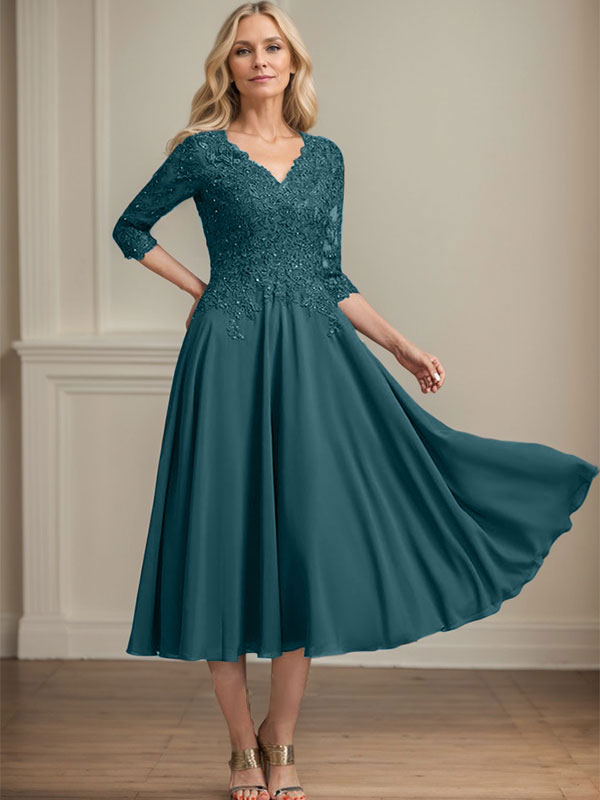 Vestido de corte A, escote en V, largo hasta la rodilla, de gasa, encaje, con lentejuelas y pedrería para la madre de la novia. 