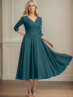 Vestido de corte A, escote en V, largo hasta la rodilla, de gasa, encaje, con lentejuelas y pedrería para la madre de la novia. 