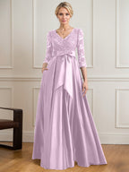 Vestido de novia de satén con encaje, corte en A, escote en V y largo hasta el suelo, con lazo de lentejuelas. 