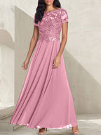 Vestido largo de corte A, color gris carbón, con escote redondo y detalles de pedrería, ideal para la madre de la novia.