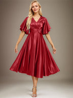 Vestido de novia de satén elástico, corte en A, escote en V, largo hasta la rodilla, con cuentas y pliegues. 