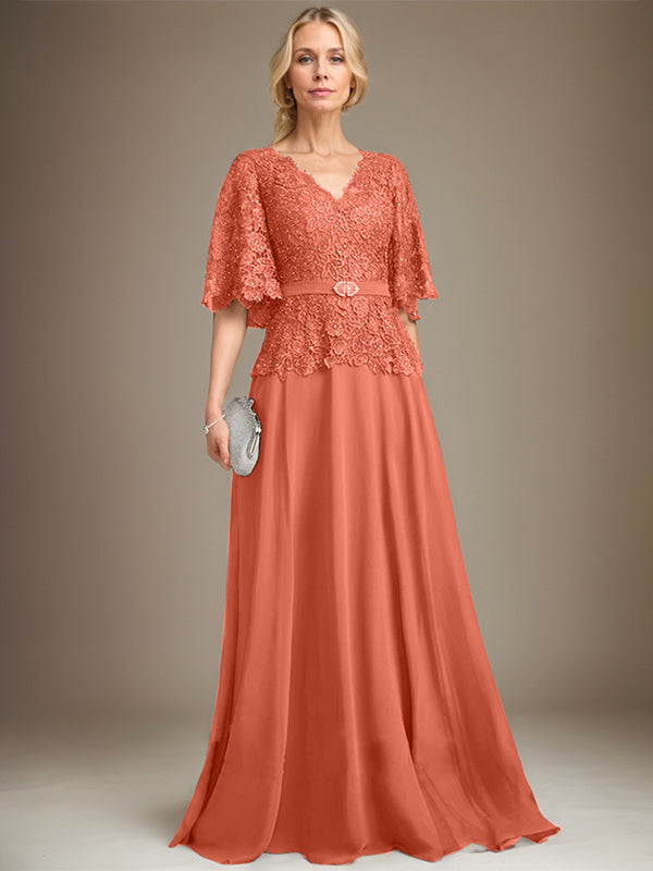 Vestido de novia de corte A, escote en V, largo hasta el suelo, de gasa y encaje, con broche de cristal y pedrería. 