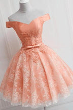 Robe de soirée simple en tulle à épaules dénudées et coupe trapèze, ornée d'appliqués.
