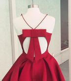 Vestido de fiesta burdeos de satén, corte en A, tirantes finos, espalda descubierta y lazo.