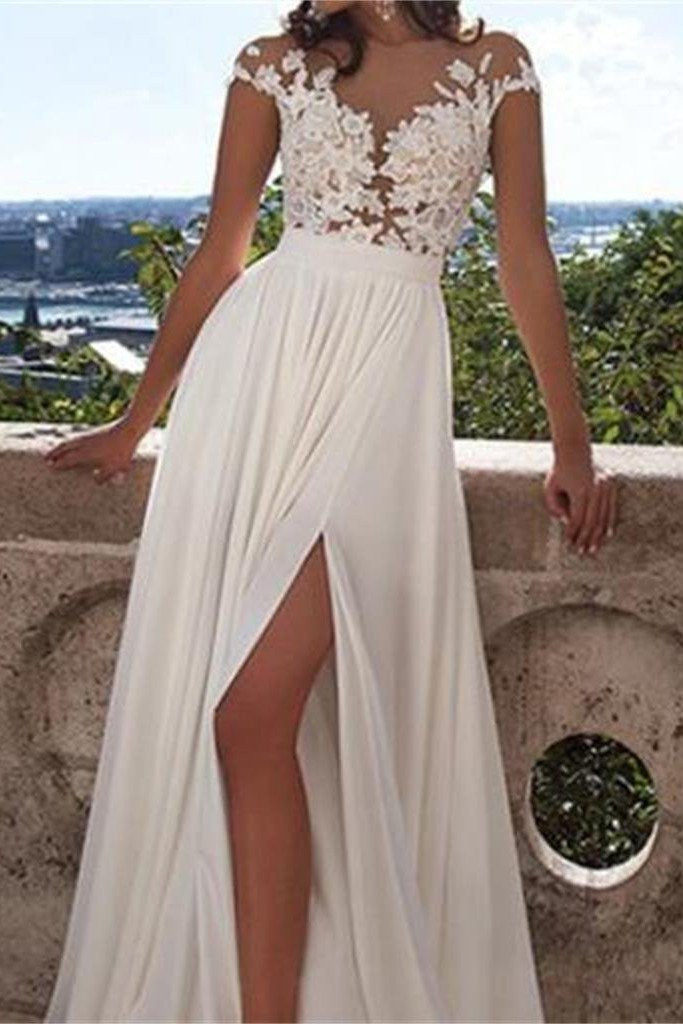Vestido de novia blanco de encaje con corte en A, abertura frontal y apliques.